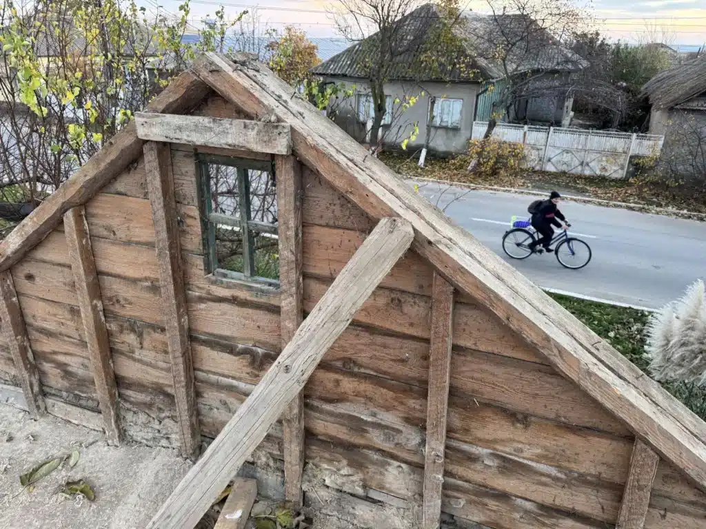 Lemnăria veche a unui fronton la casa din 1893 din Jurilovca, desfăcută cu grijă în timpul restaurării, cu strada satului în spate