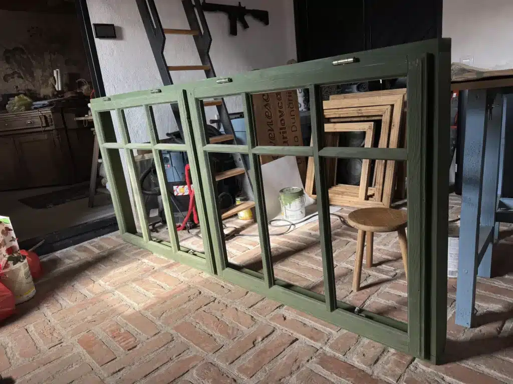 Fereastră dublă veche de aproape 90 de ani, restaurată și vopsită în verde, sprijinită pe podeaua de cărămidă